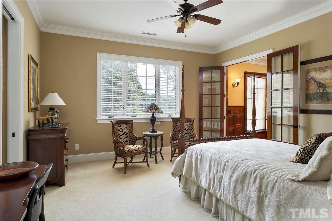 302 Annandale Drive Cary, NC 27511 - Photo 24 of 30 a bedroom with a bed and a chandelier