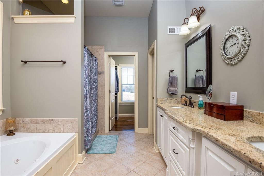 2056 Roadrunner Road Clover, SC 29710 - Photo 13 of 25 a spacious bathroom with a granite countertop sink and a mirror