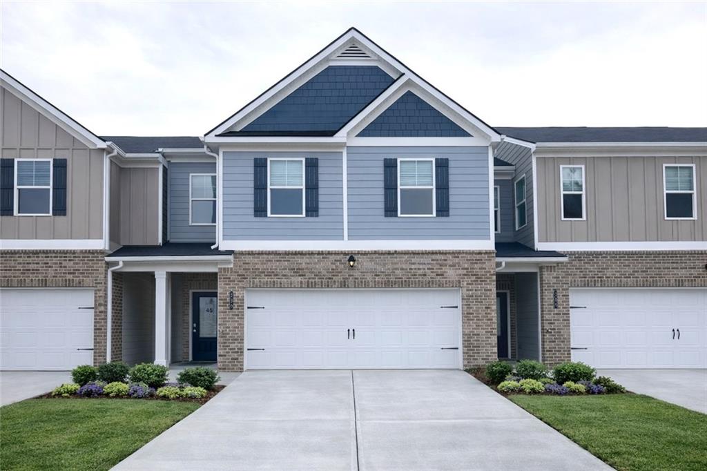 a front view of a house with yard and parking