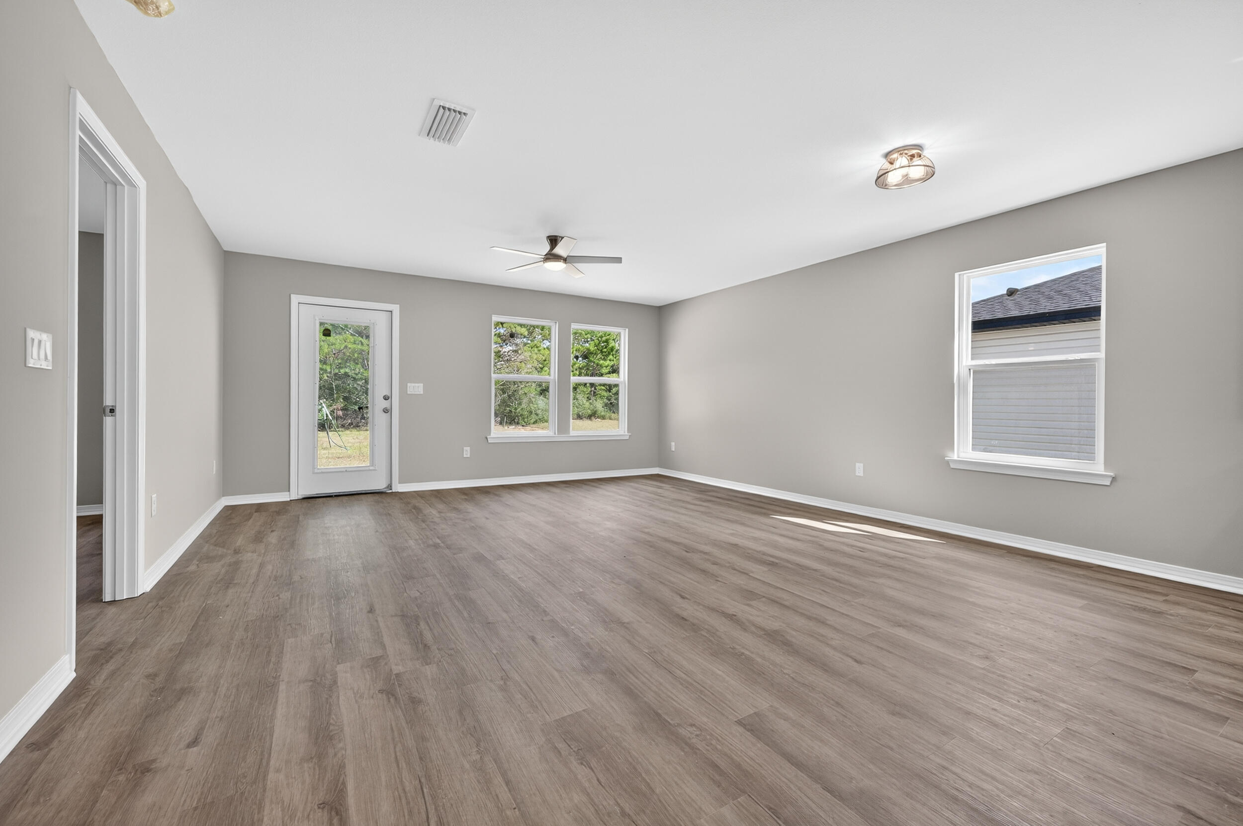 5325 B Kervin Road Crestview, FL 32539 - Photo 18 of 44 an empty room with wooden floor and windows