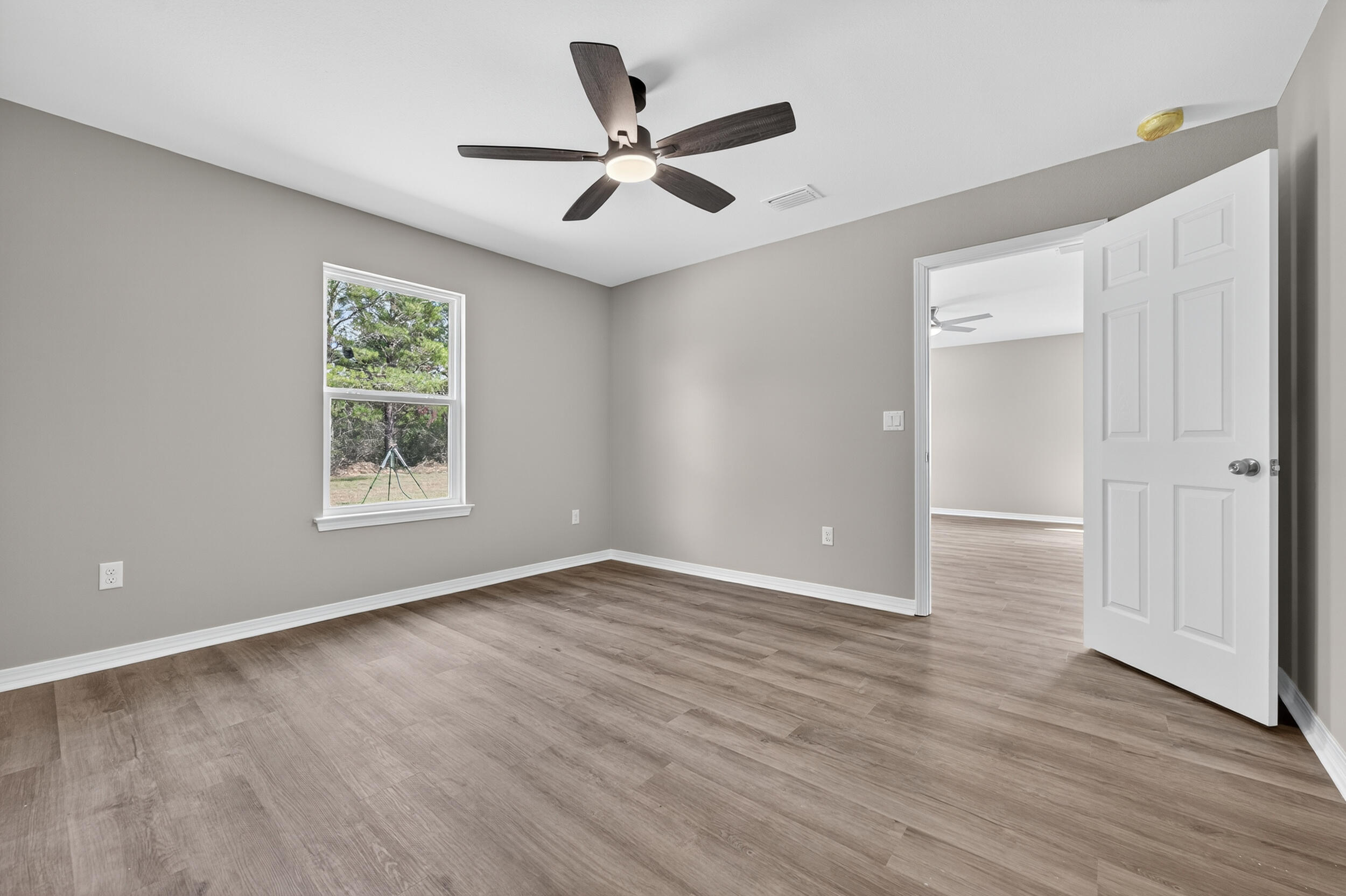 5325 B Kervin Road Crestview, FL 32539 - Photo 22 of 44 an empty room with wooden floor and windows