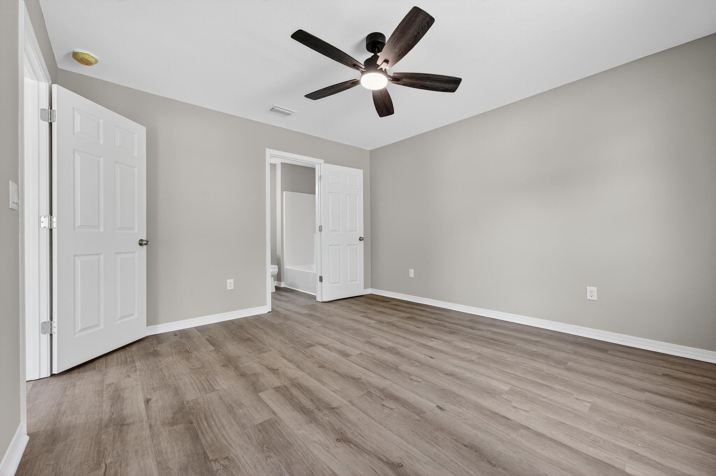 5325 B Kervin Road Crestview, FL 32539 - Photo 24 of 44 an empty room with wooden floor and ceiling fan