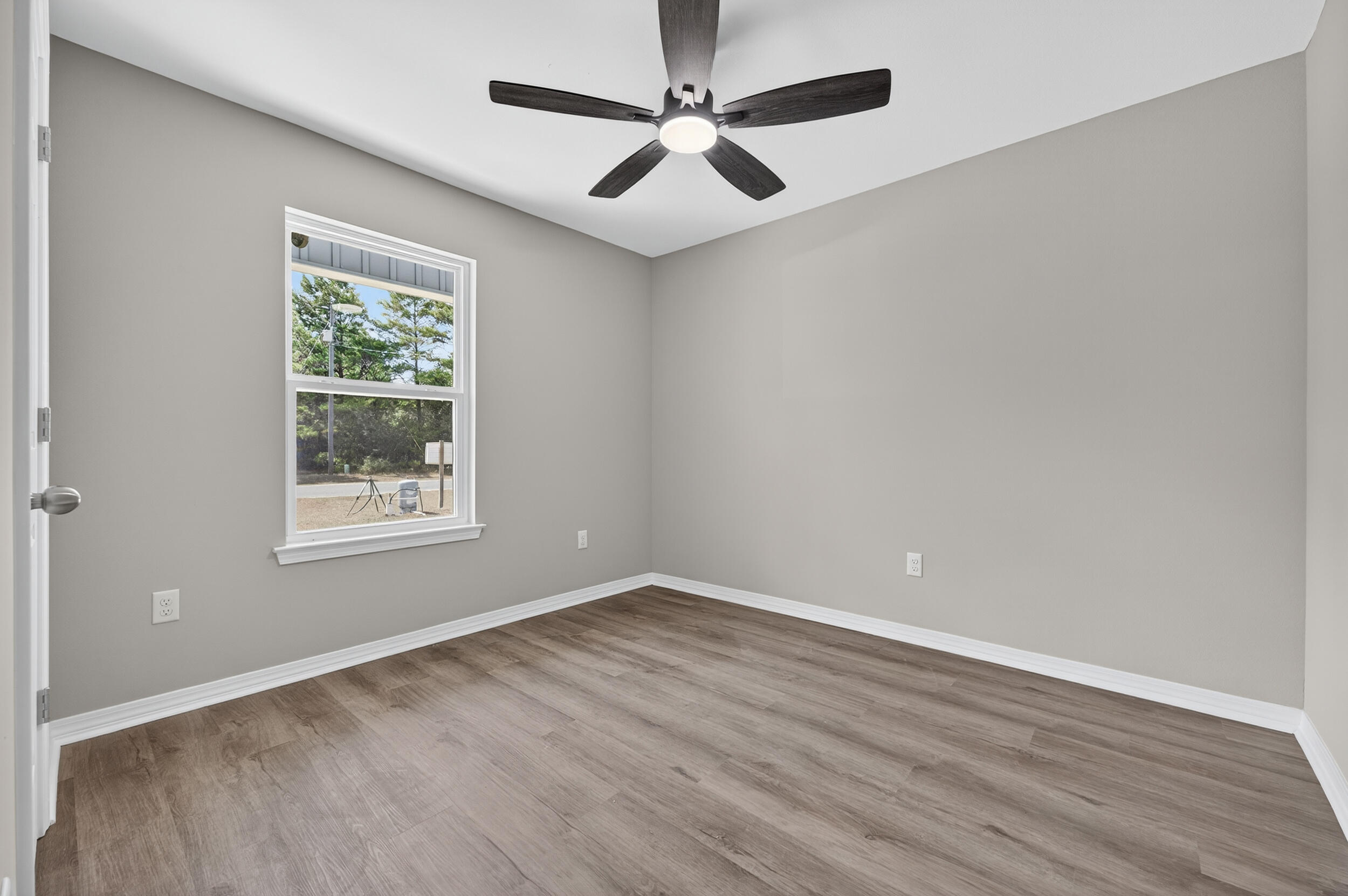 5325 B Kervin Road Crestview, FL 32539 - Photo 28 of 44 an empty room with wooden floor ceiling fan and windows