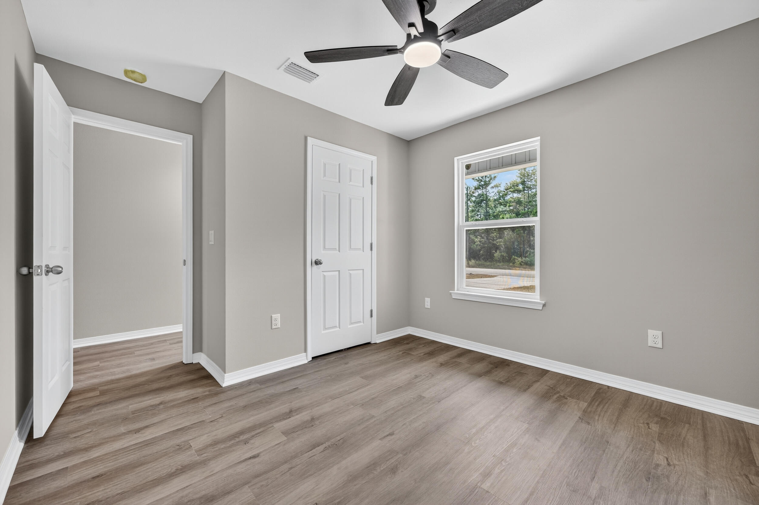 5325 B Kervin Road Crestview, FL 32539 - Photo 29 of 44 a view of an empty room with wooden floor and a window