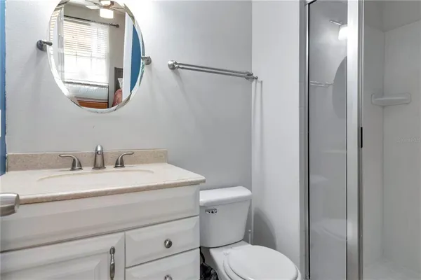 a bathroom with a toilet sink vanity and mirror