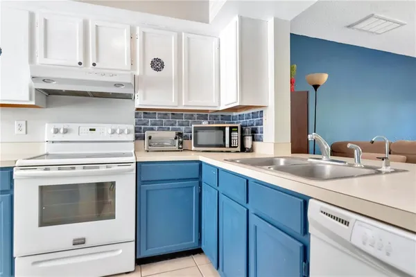 a kitchen with granite countertop a white stove and cabinets