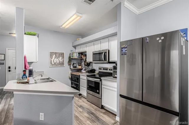 a kitchen with stainless steel appliances a stove sink microwave and cabinets