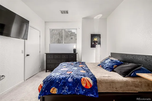 a bedroom with a bed a table and chair