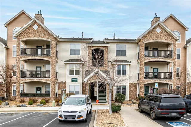 a front view of a house with cars parked