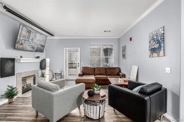 a living room with a fireplace and potted plant