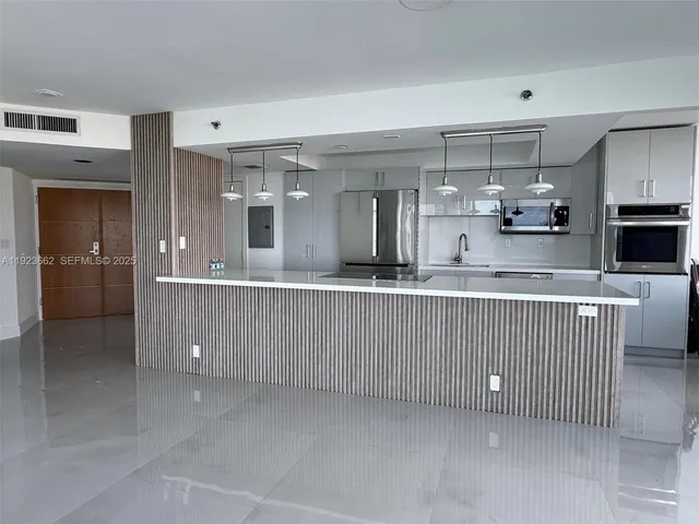 a kitchen with kitchen island cabinets and refrigerator