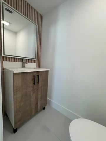 a bathroom with a sink a toilet and mirror