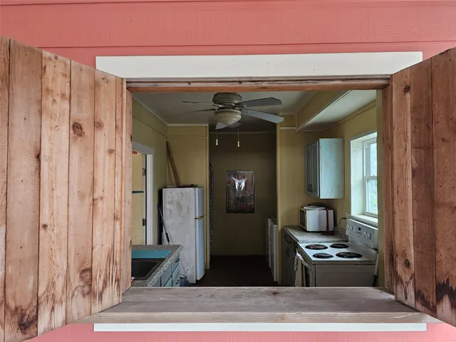 a kitchen view with wooden floor and a hallway