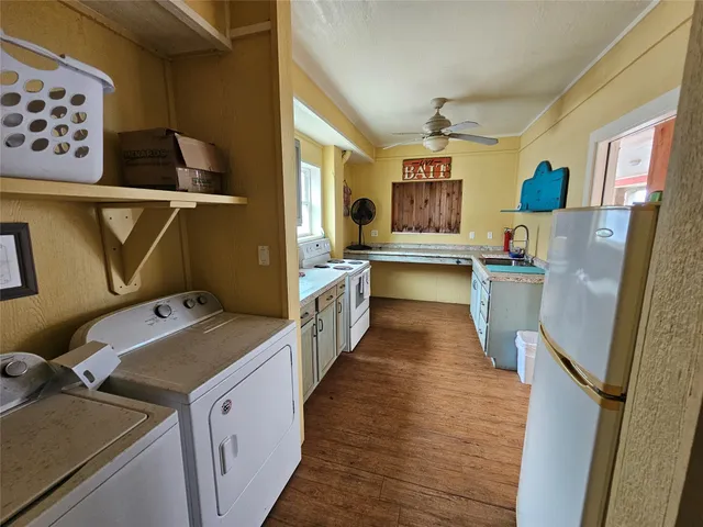 a view of a kitchen with fridge and wooden floor