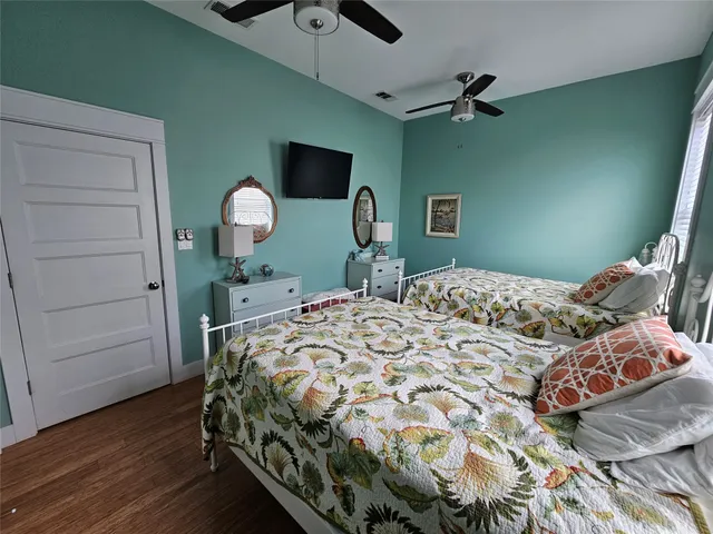 a bedroom with a bed and a flat tv screen on dresser