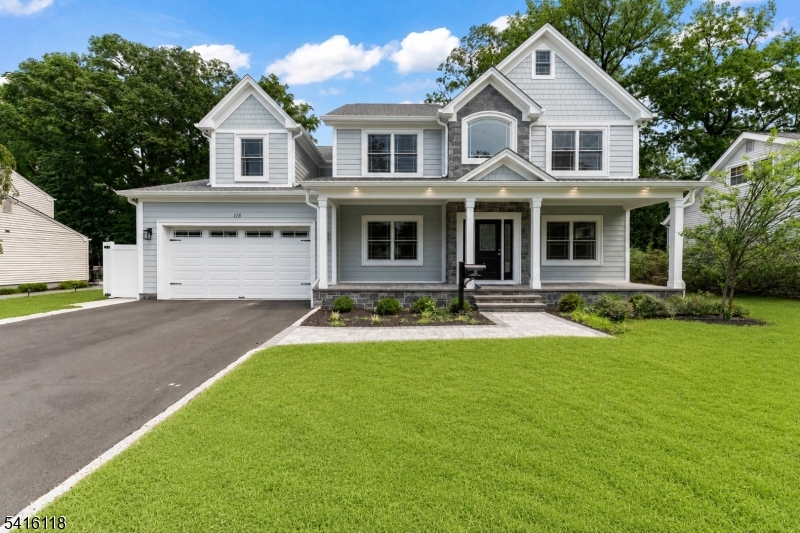 a front view of a house with yard and green space