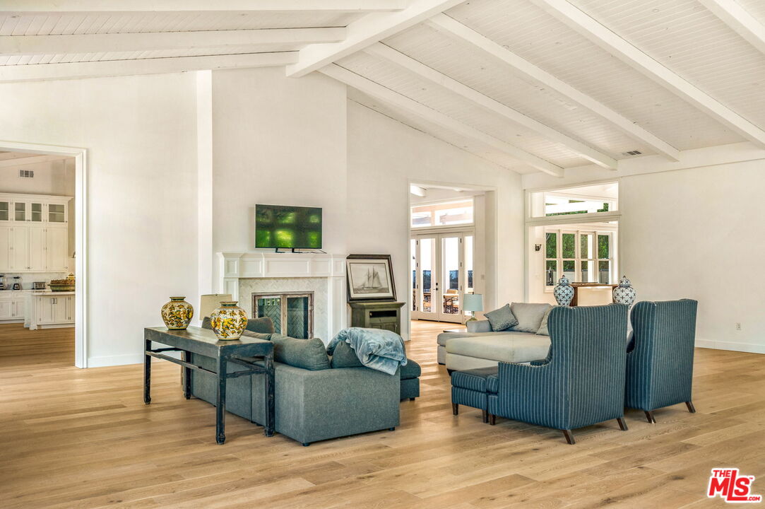 9669 Oak Pass Road Beverly Hills, CA 90210 - Photo 15 of 37 a living room with fireplace furniture and a wooden floor