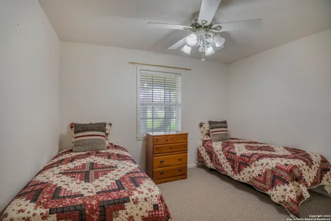 a bedroom with two beds and a chandelier