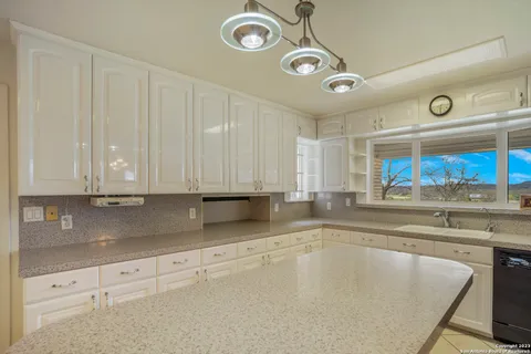 a kitchen with stainless steel appliances granite countertop a sink and cabinets