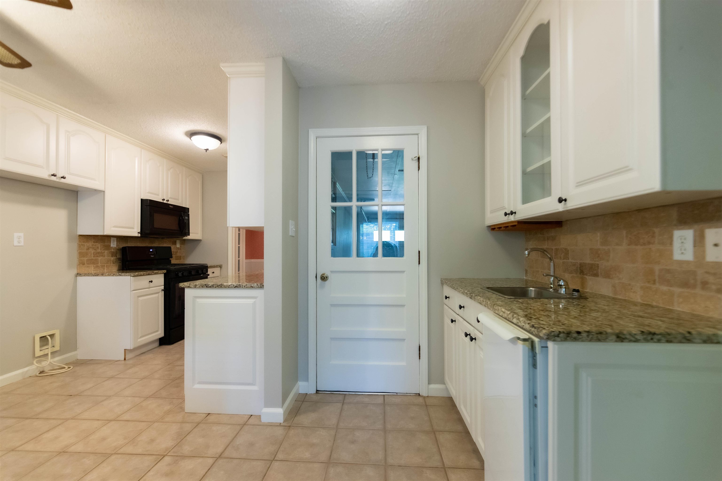 653 Oak Wild Cove Collierville, TN 38017 - Photo 12 of 20 Kitchen with black appliances, white cabinetry, and stone countertops