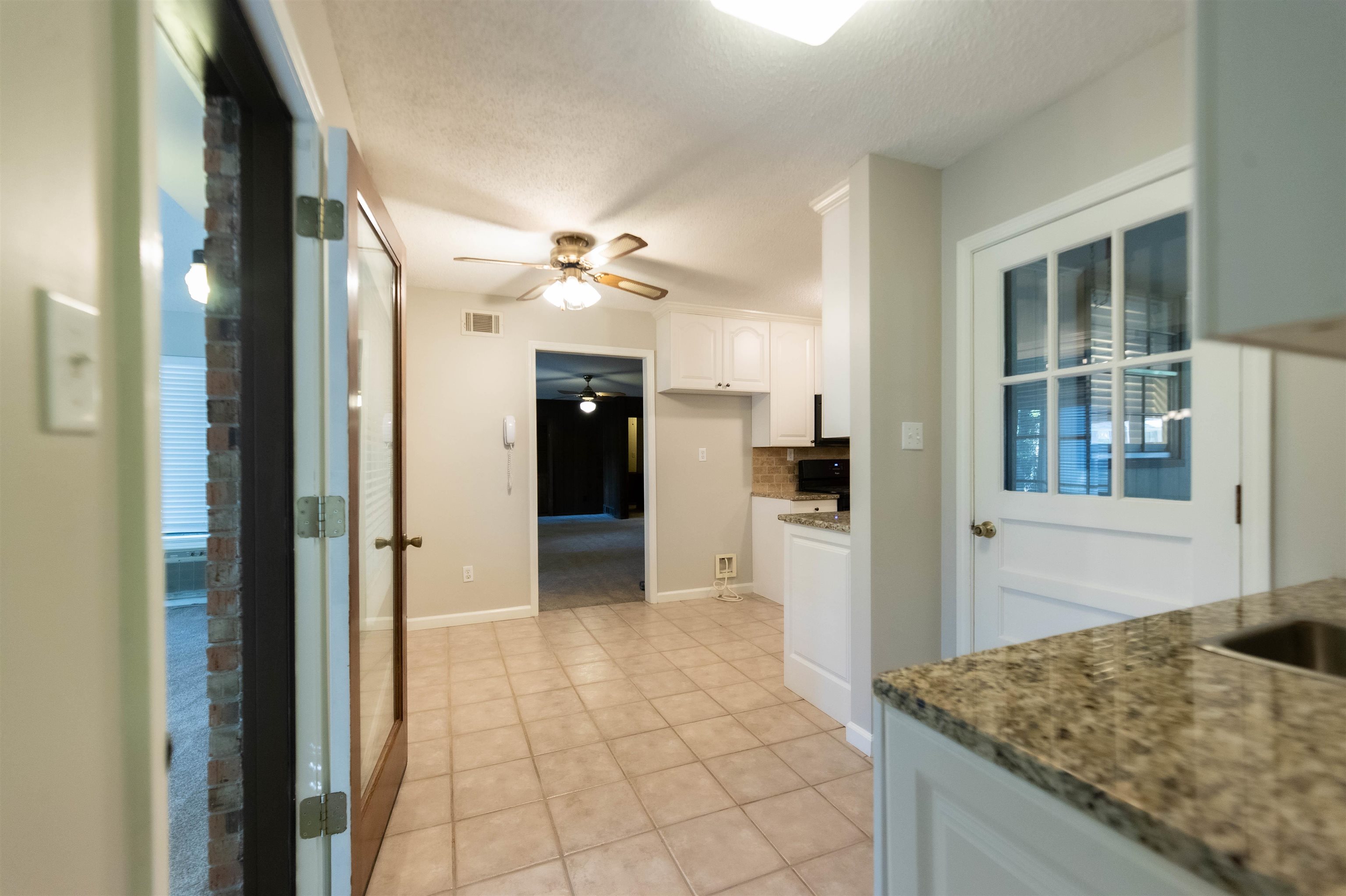 653 Oak Wild Cove Collierville, TN 38017 - Photo 13 of 20 Kitchen with ceiling fan, white cabinets, light tile patterned floors, stone countertops, and a textured ceiling