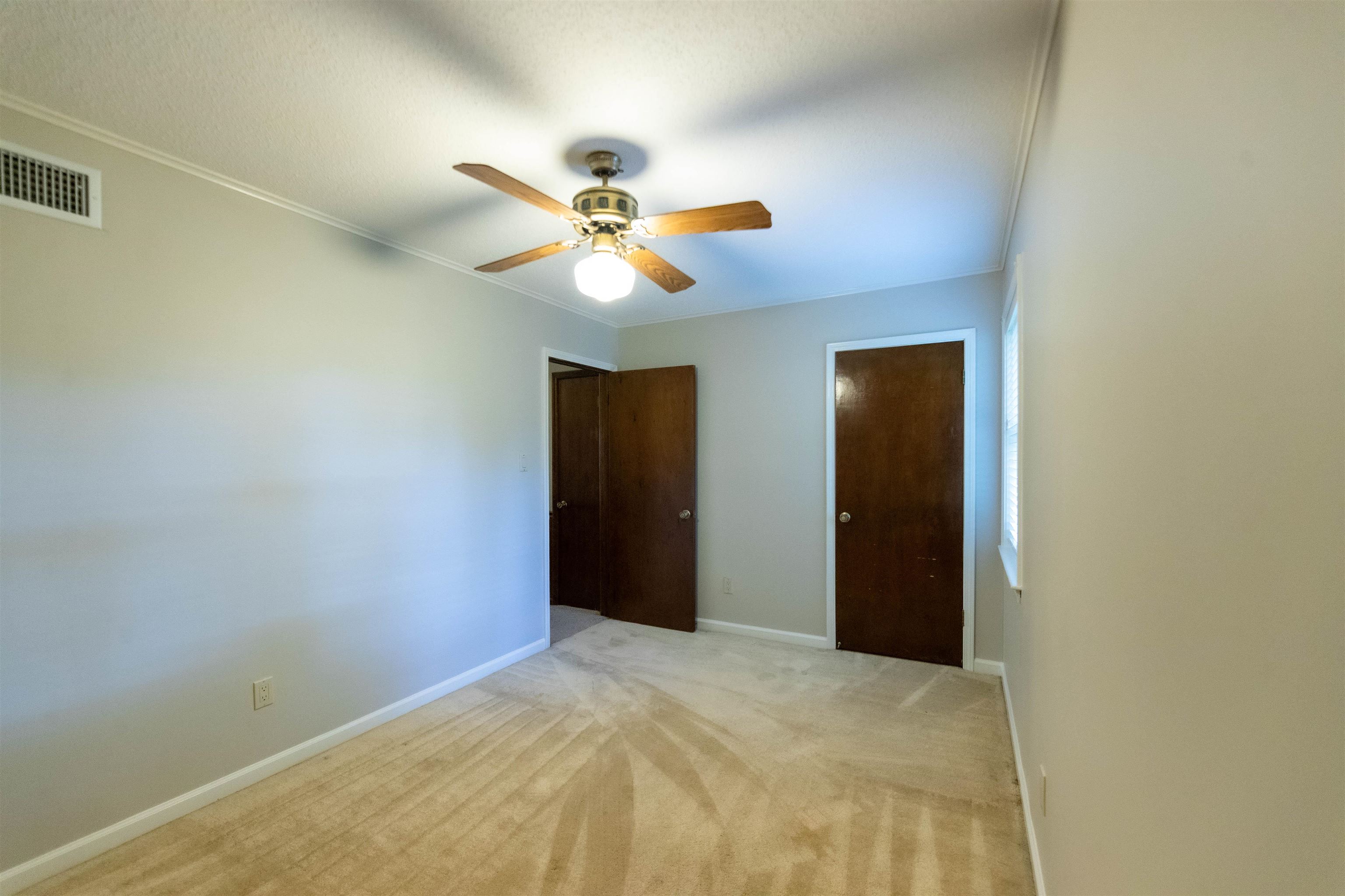 653 Oak Wild Cove Collierville, TN 38017 - Photo 16 of 20 Unfurnished bedroom with light carpet, a closet, ceiling fan, and crown molding