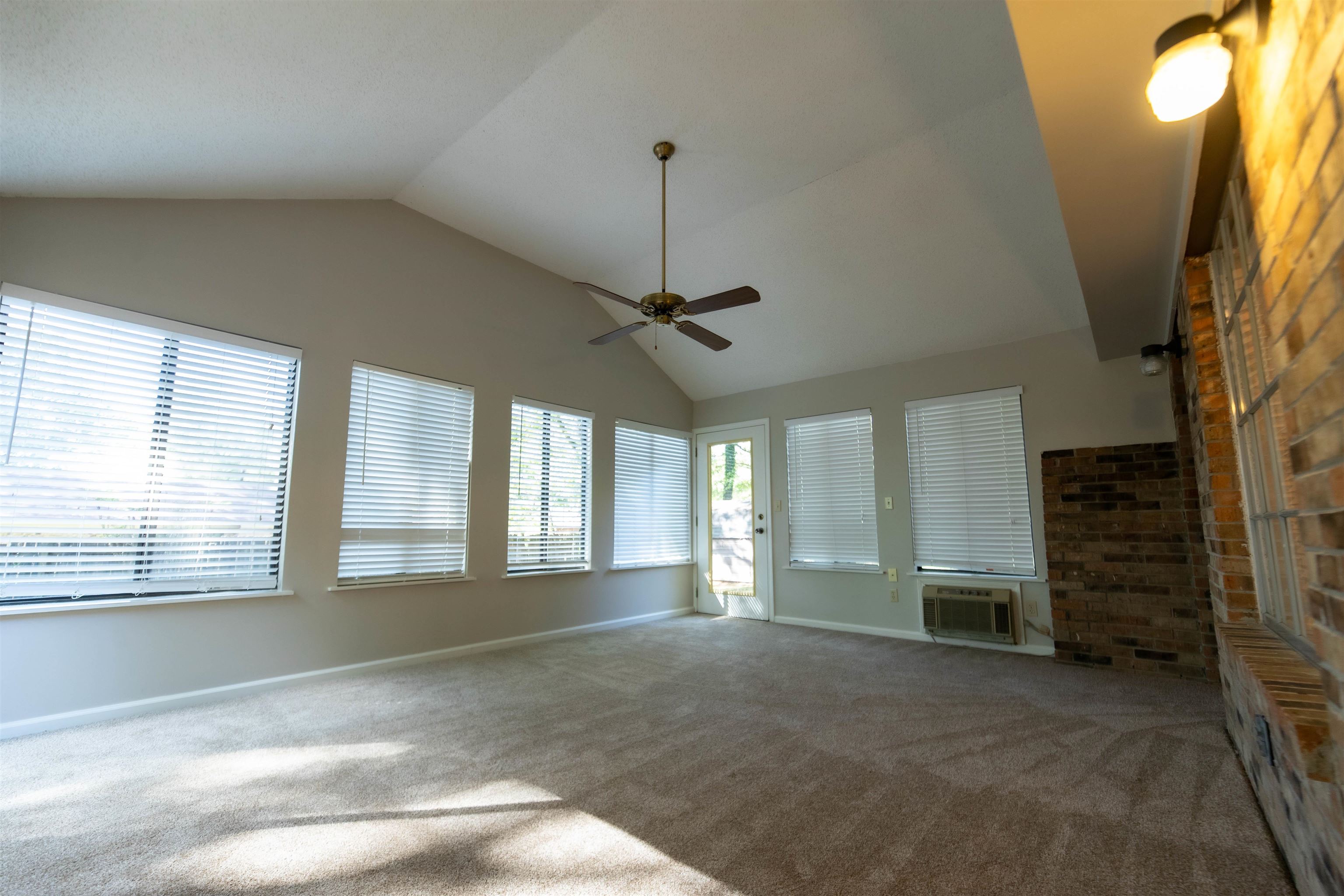653 Oak Wild Cove Collierville, TN 38017 - Photo 5 of 20 Unfurnished living room with ceiling fan, vaulted ceiling, carpet flooring, and a wall unit AC