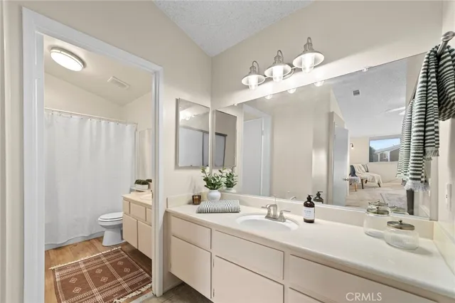 a bathroom with a double vanity sink mirror and toilet
