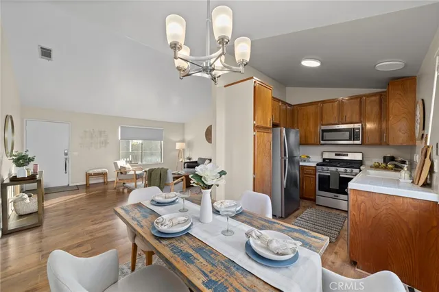 a kitchen with stainless steel appliances kitchen island granite countertop a dining table and chairs