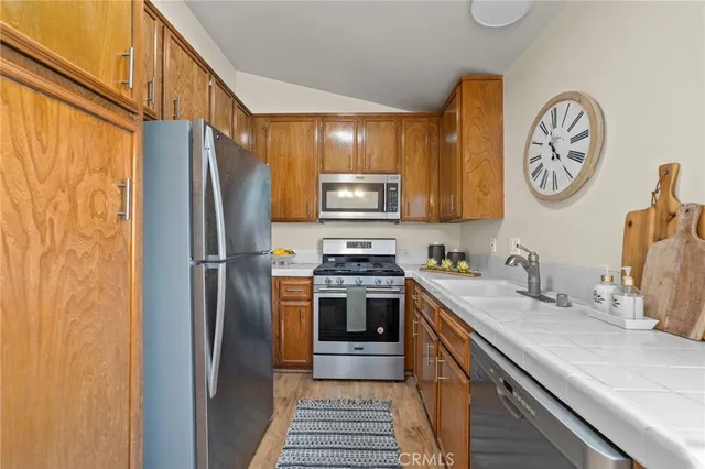 a kitchen with stainless steel appliances granite countertop a refrigerator and a stove top oven