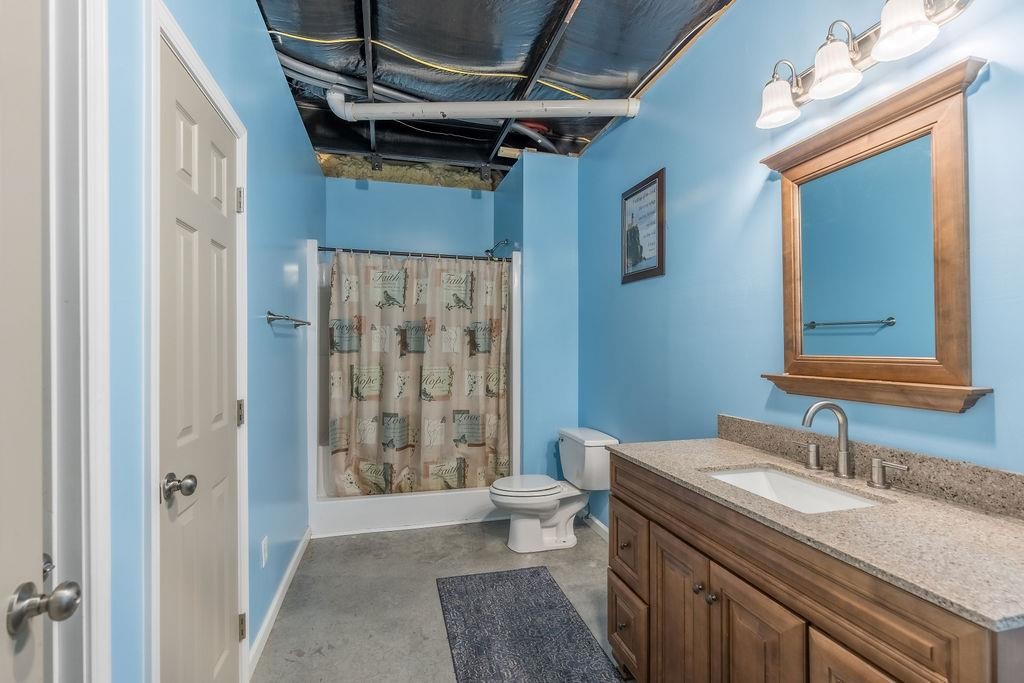 321 Archie Lane Dawson Springs, KY 42408 - Photo 25 of 42 a bathroom with a granite countertop sink a toilet a mirror and shower