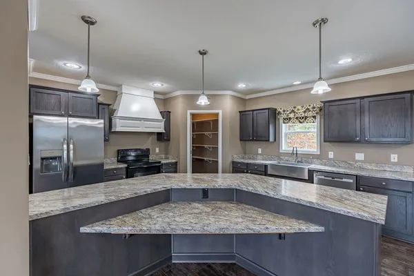a kitchen with stainless steel appliances granite countertop a sink a counter space cabinets and wooden floor
