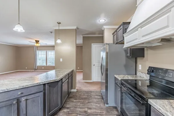a kitchen with granite countertop a sink and refrigerator