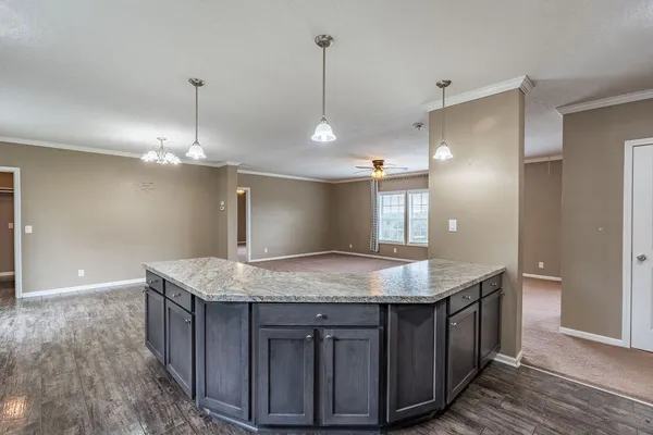 a kitchen with kitchen island a counter top space appliances and a chandelier