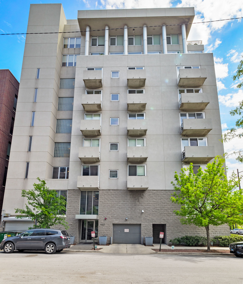 a front view of a building with a garden and plants