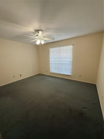 an empty room with a ceiling fan and a window