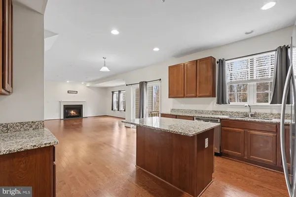a kitchen with stainless steel appliances granite countertop a stove top oven a sink and a refrigerator