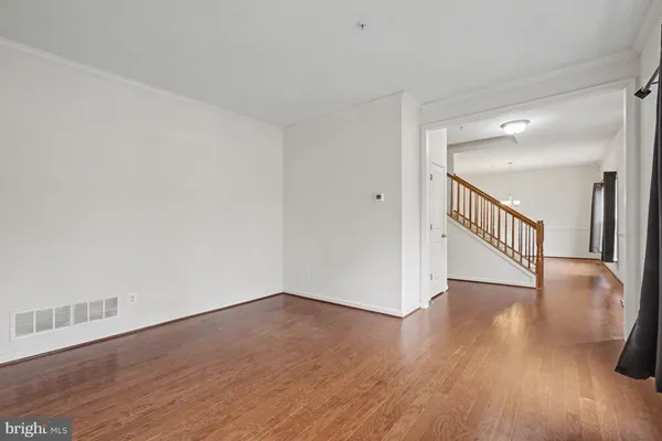 a view of an empty room with wooden floor