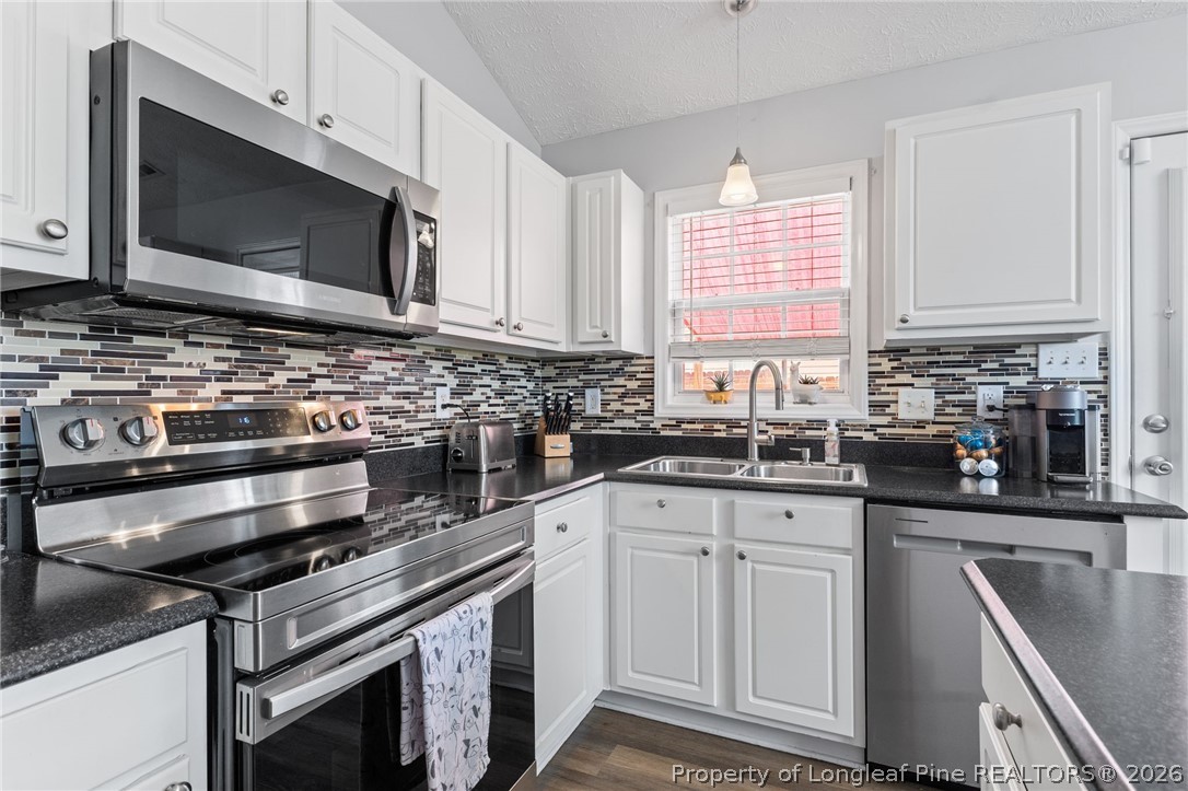 122 Raymond Street Raeford, NC 28376 - Photo 12 of 36 a kitchen with stainless steel appliances a stove microwave and sink