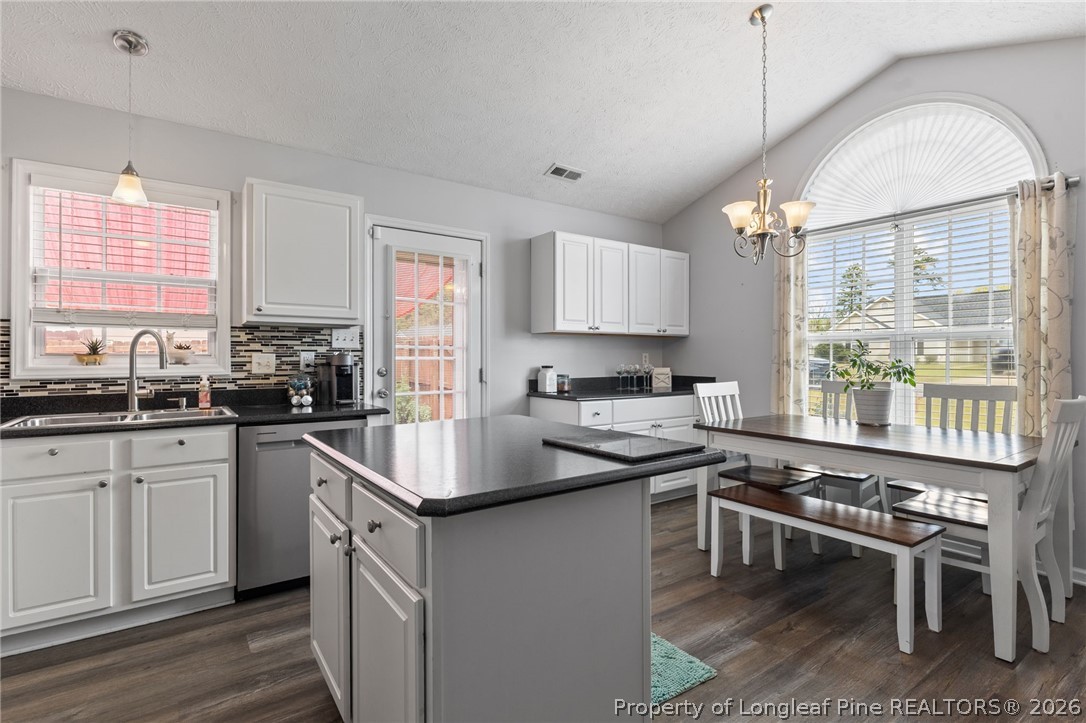122 Raymond Street Raeford, NC 28376 - Photo 13 of 36 a kitchen with a stove a sink a dining table and chairs
