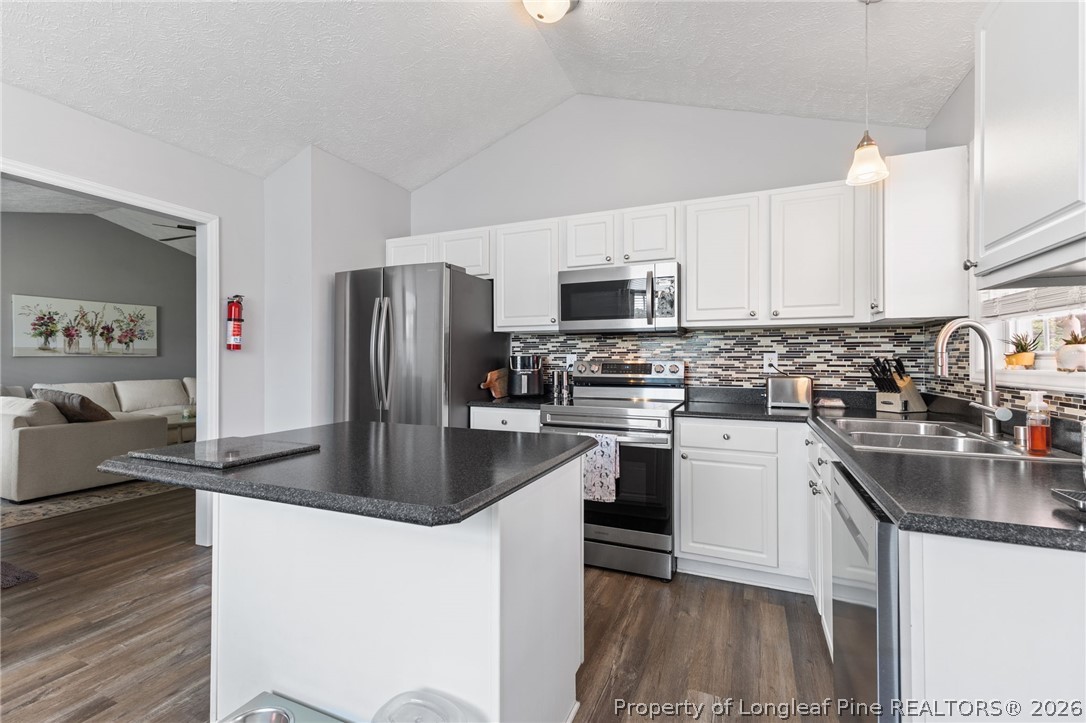122 Raymond Street Raeford, NC 28376 - Photo 14 of 36 a kitchen with kitchen island a refrigerator stove and sink