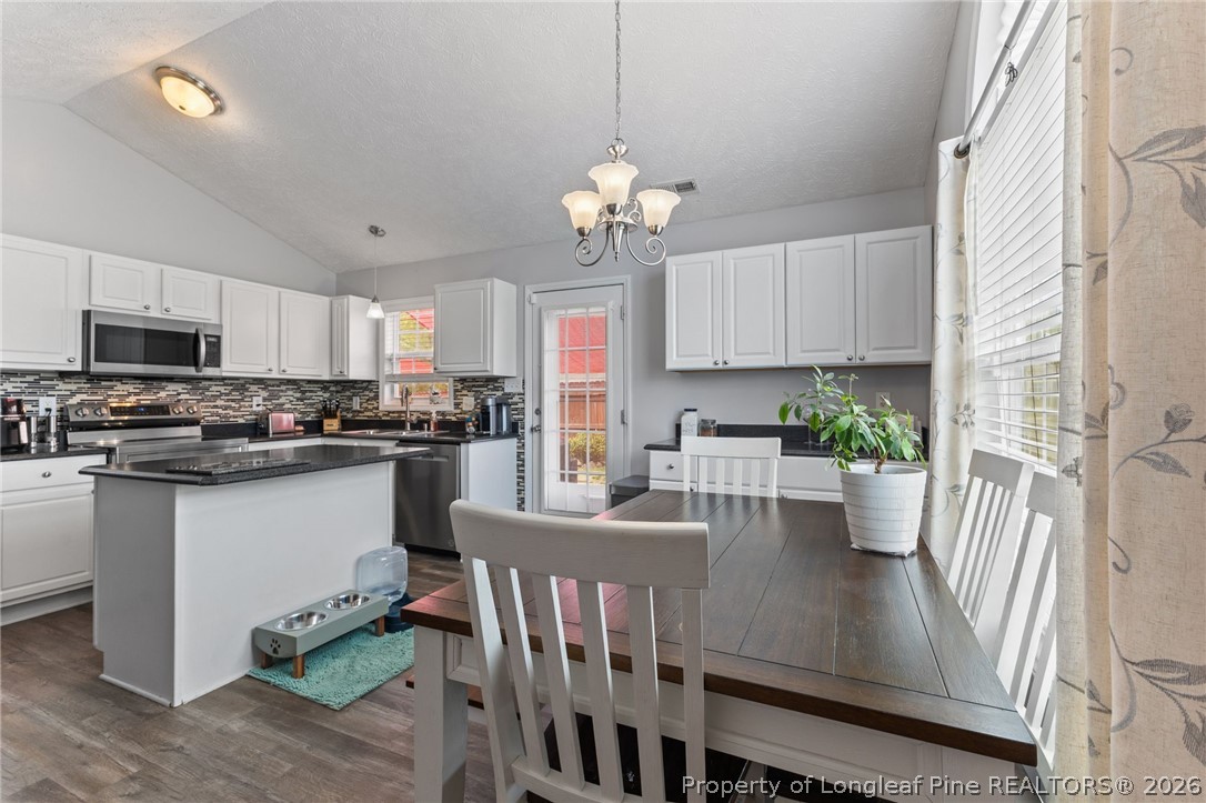 122 Raymond Street Raeford, NC 28376 - Photo 15 of 36 a view of a dining room with furniture a kitchen and chandelier