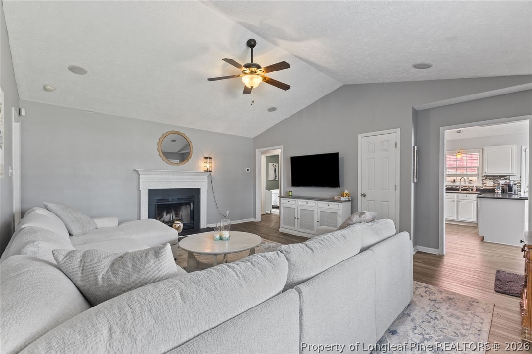 122 Raymond Street Raeford, NC 28376 - Photo 7 of 36 a living room with furniture a fireplace and a flat screen tv