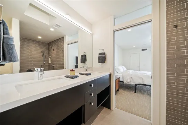 a en suite bathroom with a double vanity sink and a mirror