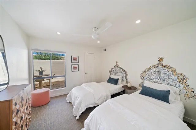 a bedroom with two beds and large window