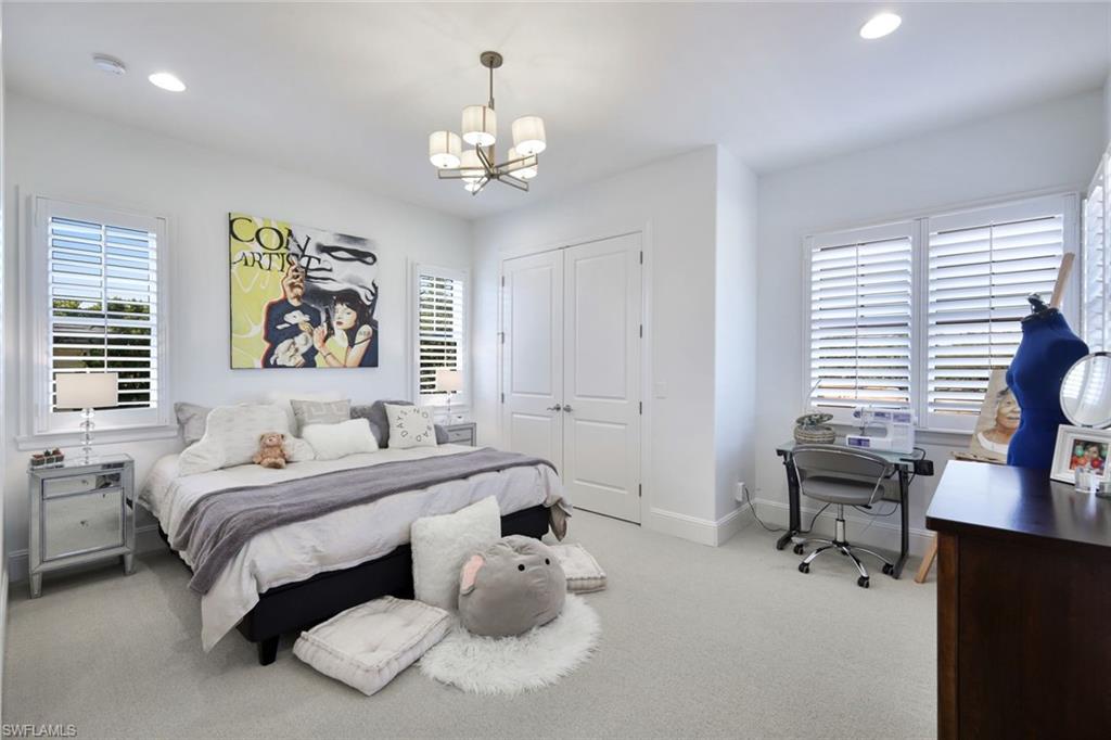 16699 Pistoia Way Naples, FL 34110 - Photo 26 of 48 a bedroom with a bed and a chandelier