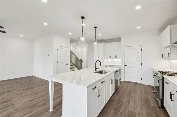 a kitchen with kitchen island a sink appliances and wooden floor