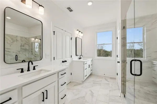 a bathroom with a double vanity sink mirror and bathtub