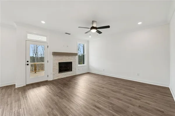 a view of empty room with wooden floor and fireplace