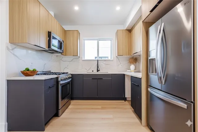 a kitchen with stainless steel appliances granite countertop a sink stove and refrigerator